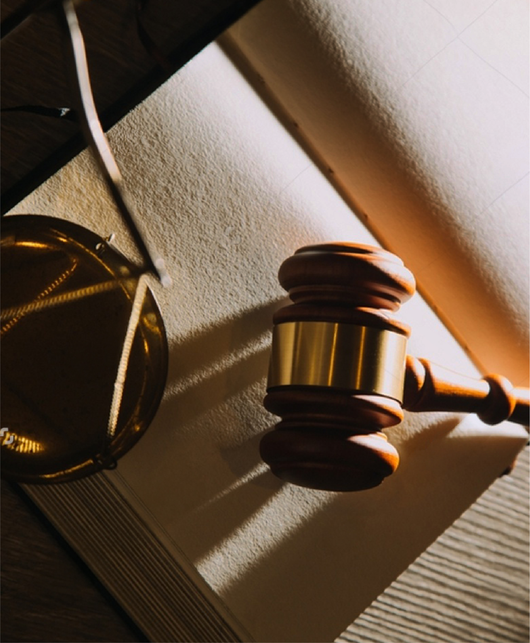 Gavel, legal scales, and law books with dramatic lighting